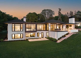 A modern home glowing at sunset on Lake Minnetonka, featuring Marvin Modern Multi-Slide door, Marvin Modern Casement windows, and Marvin Modern Direct Glaze windows. 