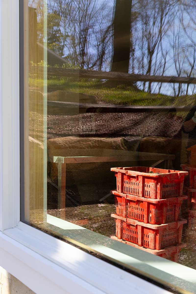 A stack of orange crates seen through a Marvin Elevate Direct Glaze window at the Deluxbury Sea Farm oyster processing facility.