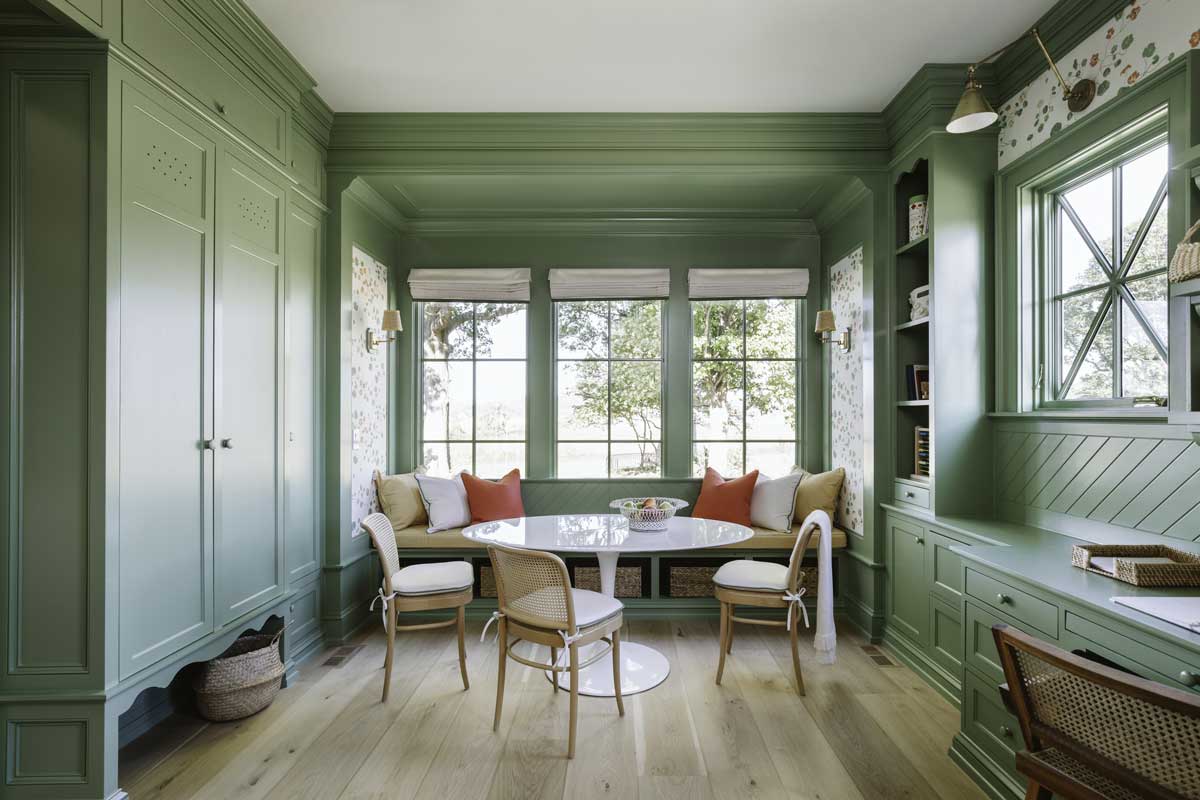 An office space in the Southern Living Idea House in Louisville, Kentucky, featuring sage green built-ins, floral wallpaper, and Marvin Ultimate Picture windows and Ultimate Casement windows.