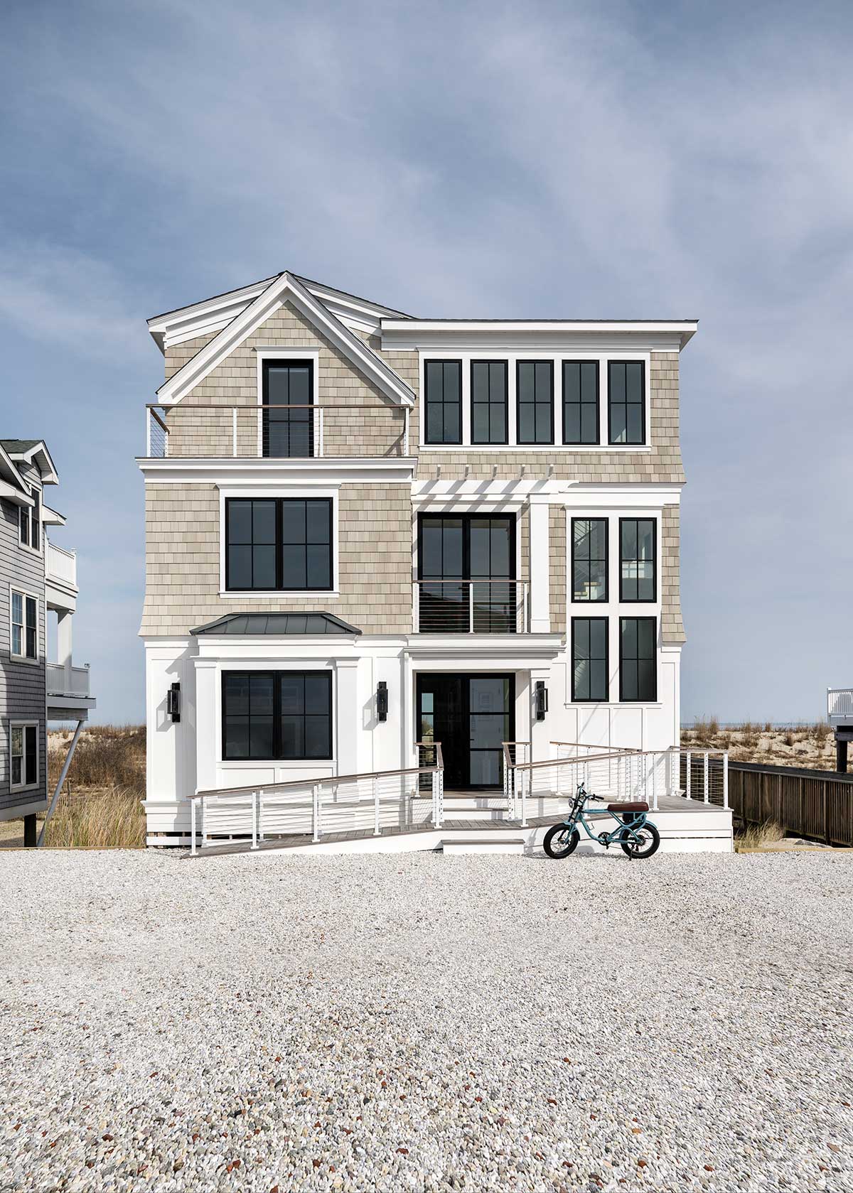 The front exterior of a home in Bethany Beach, Delaware, with a child's bike out front.