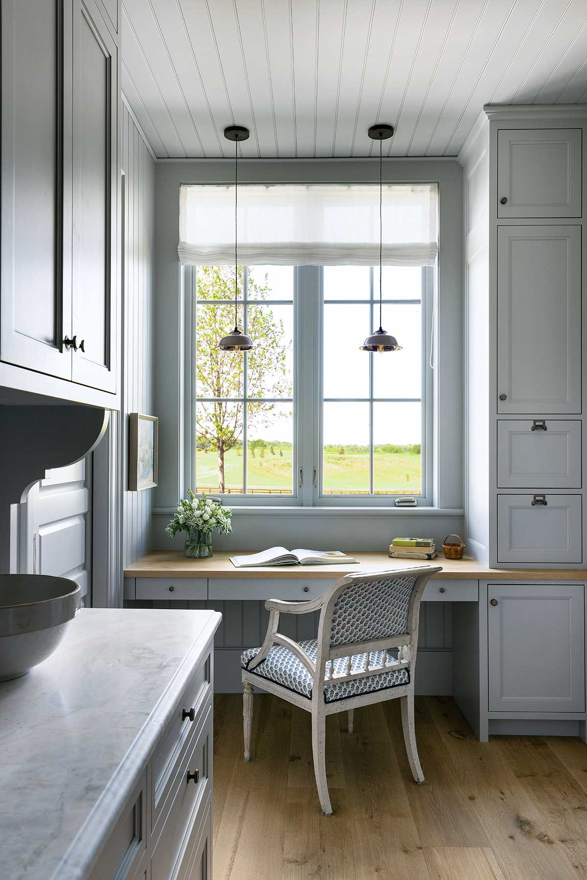 A desk below a Marvin Ultimate Casement Narrow Frame window in a Swedish-style home.