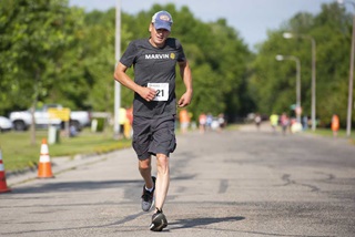 Man running in a marathon with a Marvin shirt on